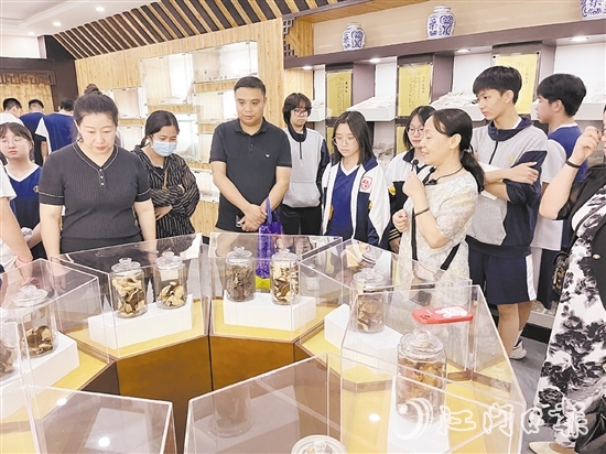 講解員向參觀者們講解標(biāo)本瓶里的珍貴藥材。