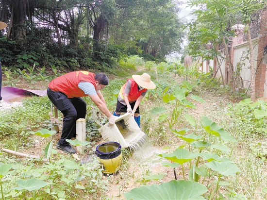 工作人員清理環(huán)境積水。