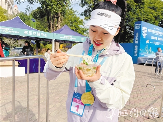 恩平溫泉半程馬拉松女子組冠軍郭利亞品嘗恩平瀨粉并點(diǎn)贊。