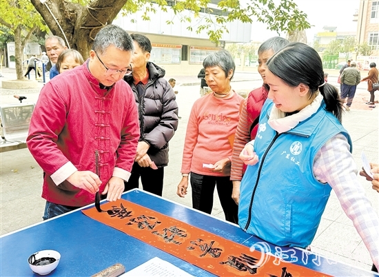 書(shū)法家手寫(xiě)春聯(lián)，為群眾送祝福。